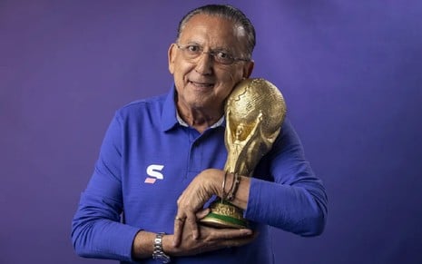 Galvão Bueno sorri e segura a taça da Copa do Mundo