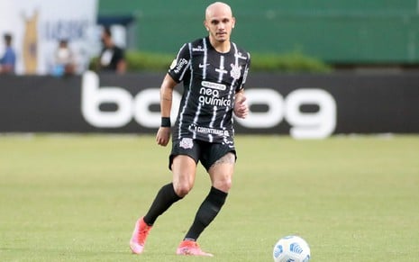 Fábio Santos com meião e calção preto e camisa preta com linhas brancas do Corinthians olha para a bola após chute