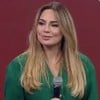 Rachel Sheherazade no evento de lançamento da nova temporada de A Grande Conquista, com expressão séria, segurando microfone